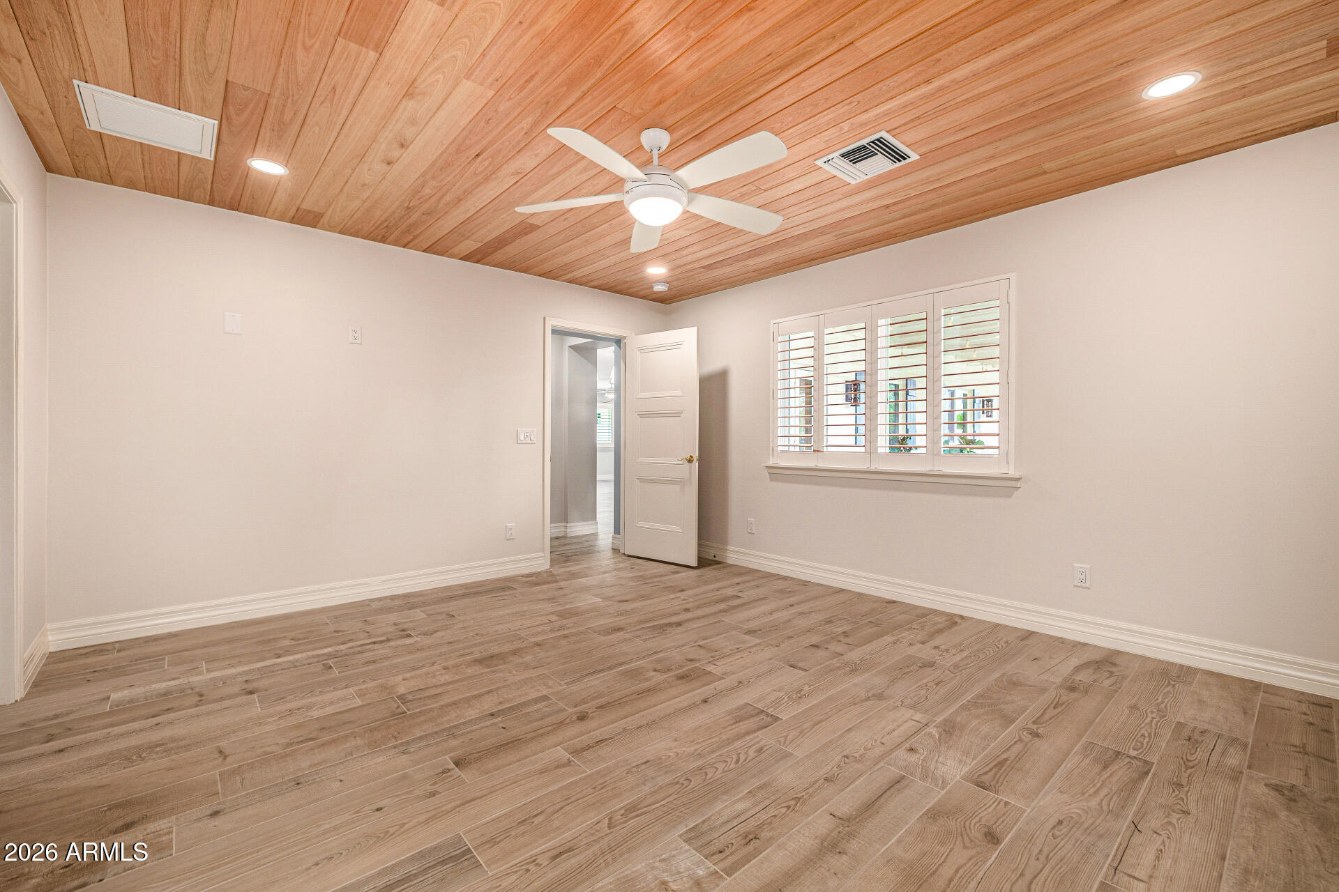 4010 East Coolidge Street Phoenix, AZ 85018 - Photo 37 of 82 a view of an empty room with wooden floor and a window