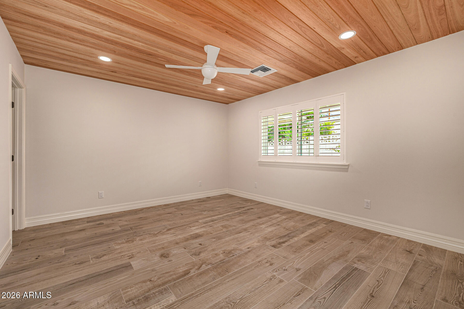 4010 East Coolidge Street Phoenix, AZ 85018 - Photo 45 of 82 an empty room with wooden floor and windows