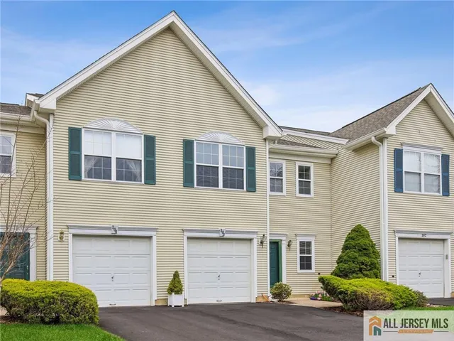 a view of a house with a yard and potted plants