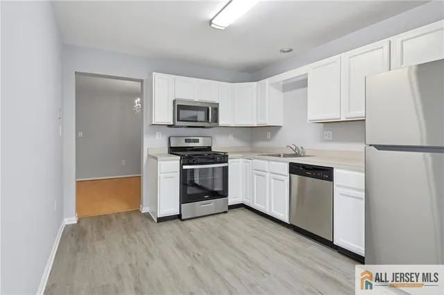 a kitchen with white cabinets and white appliances