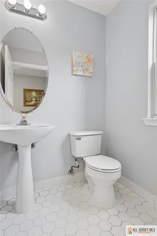 a bathroom with a toilet a sink and mirror