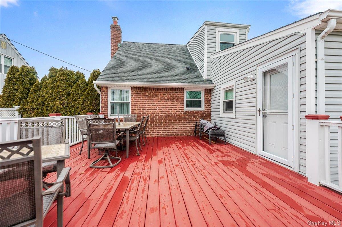 1674 Kroll Road East Meadow, NY 11554 - Photo 23 of 25 a view of deck with table and chairs wooden floor and fence