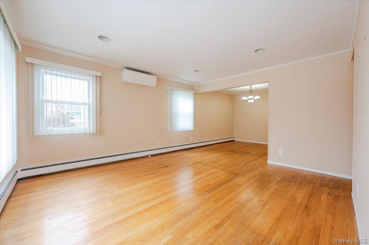 1674 Kroll Road East Meadow, NY 11554 - Photo 3 of 25 a view of an empty room with wooden floor and a window