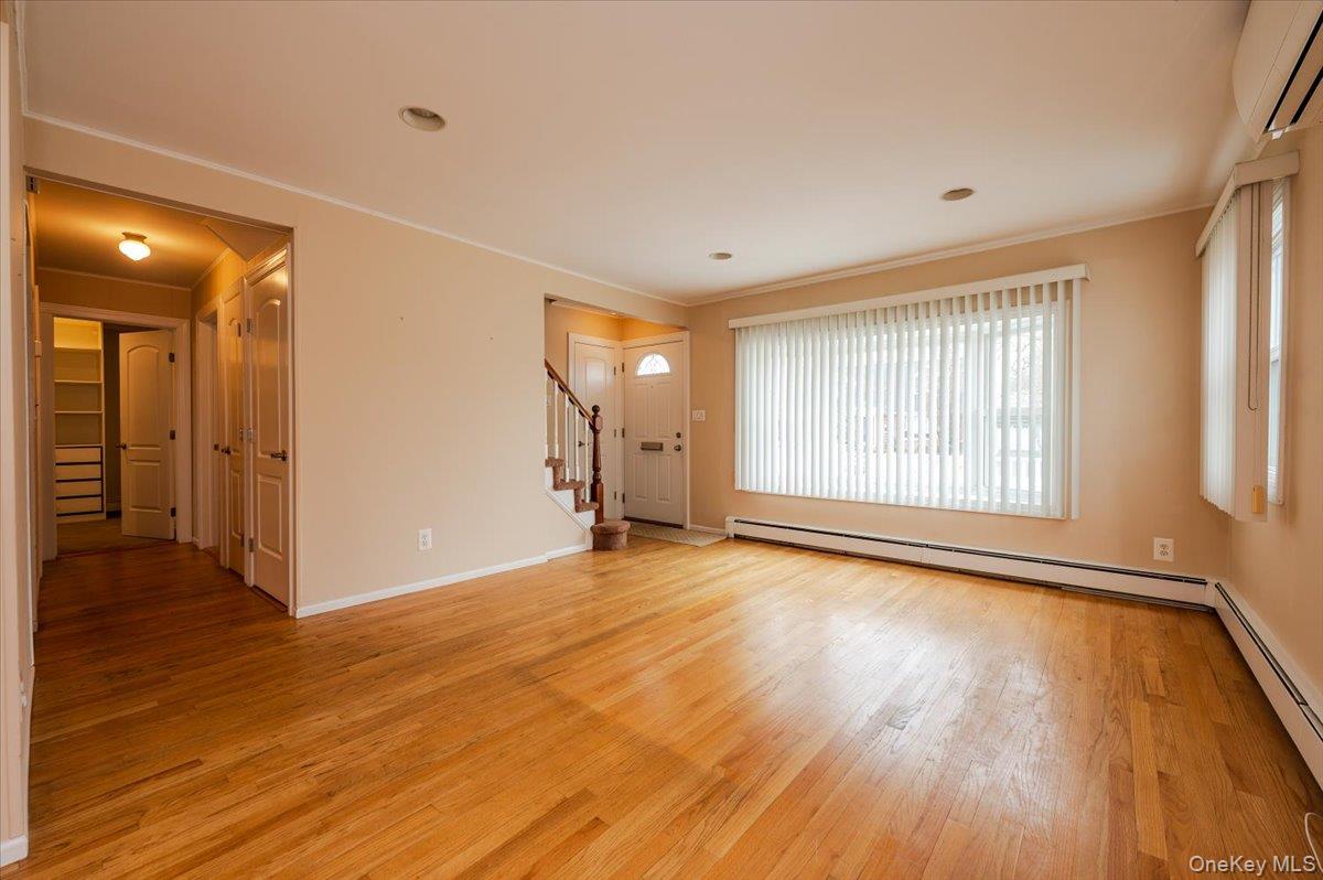 1674 Kroll Road East Meadow, NY 11554 - Photo 5 of 25 a view of an empty room with wooden floor and a window