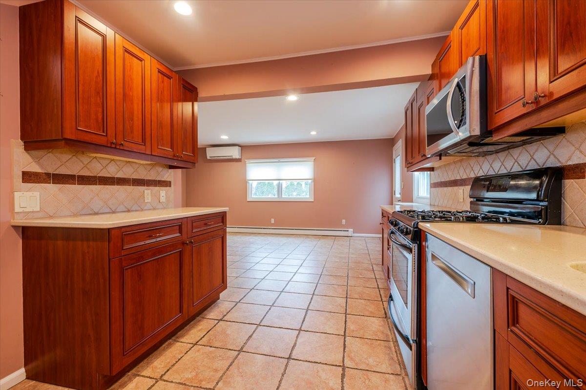 1674 Kroll Road East Meadow, NY 11554 - Photo 8 of 25 a kitchen with stainless steel appliances granite countertop a stove a sink and a microwave