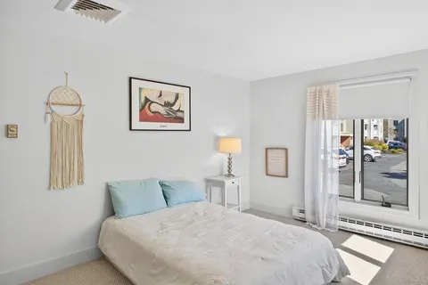 a bedroom with a bed and a painting on the wall