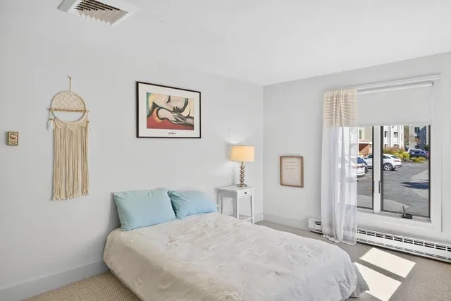 a bedroom with a bed and a painting on the wall