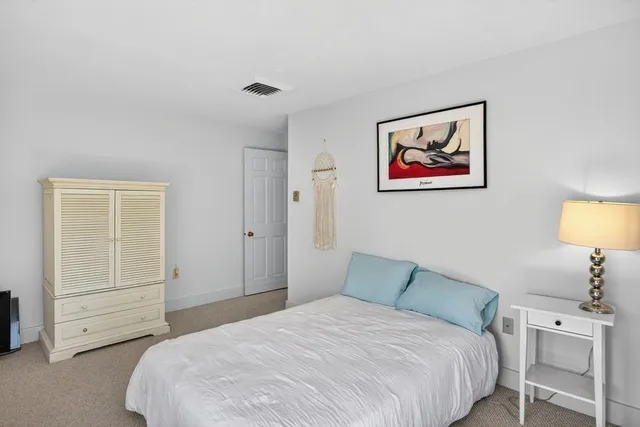 a bedroom with a bed and a lamp