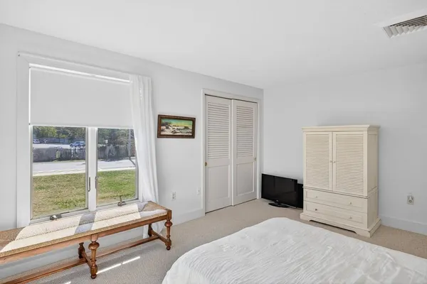 a bedroom with a bed and large window