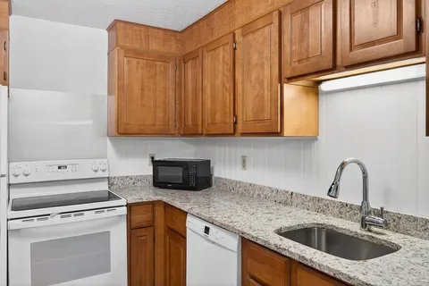a kitchen with stainless steel appliances granite countertop a sink a stove and cabinets