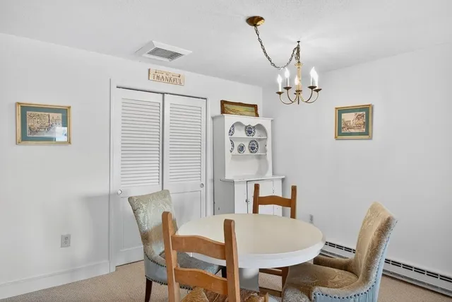 a view of a dining room with furniture and chandelier