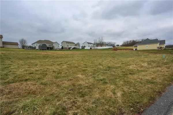a view of a big house with a big yard and large trees