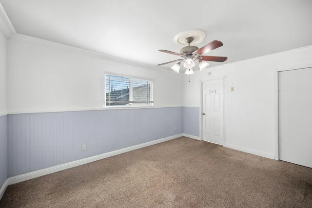 a view of a room with a ceiling fan and a window