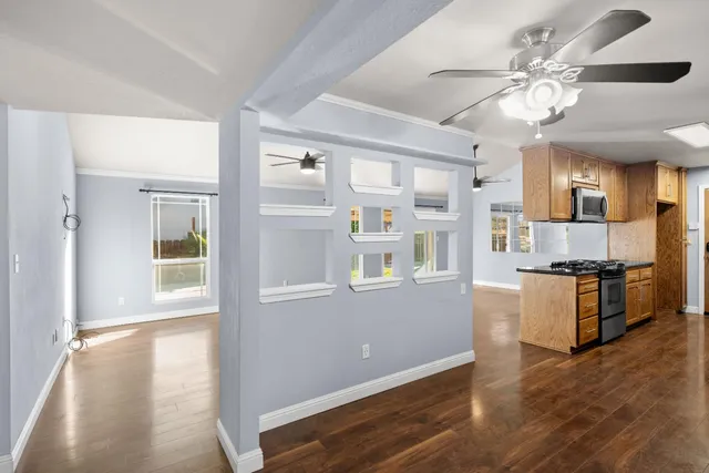 a open kitchen with cabinets a stove and a wooden floor