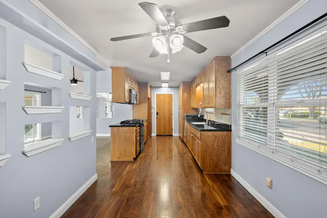 a kitchen with stainless steel appliances granite countertop lots of counter top space and wooden floors