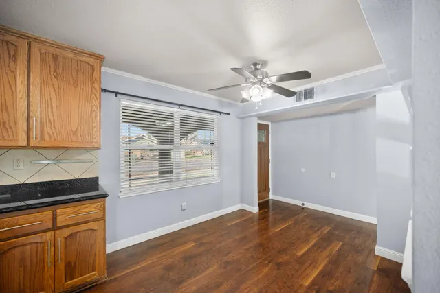 a view of an empty room with window and cabinet