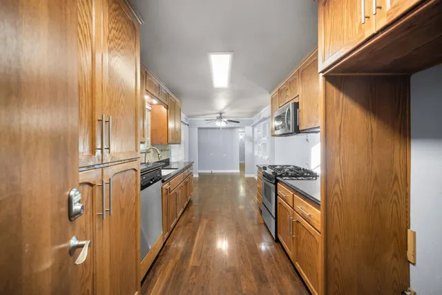 a view of a kitchen with wooden floor and stainless steel appliances