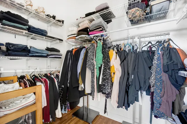 a view of walk in closet with clothes and shoes