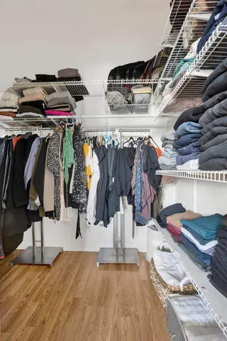 a view of walk in closet with clothes and shoes
