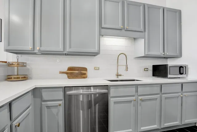 a kitchen with white cabinets and white appliances