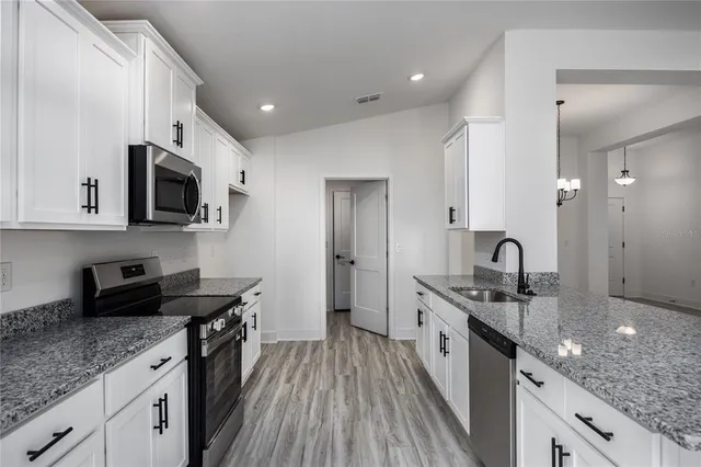 a kitchen with stainless steel appliances granite countertop a stove a sink and a refrigerator