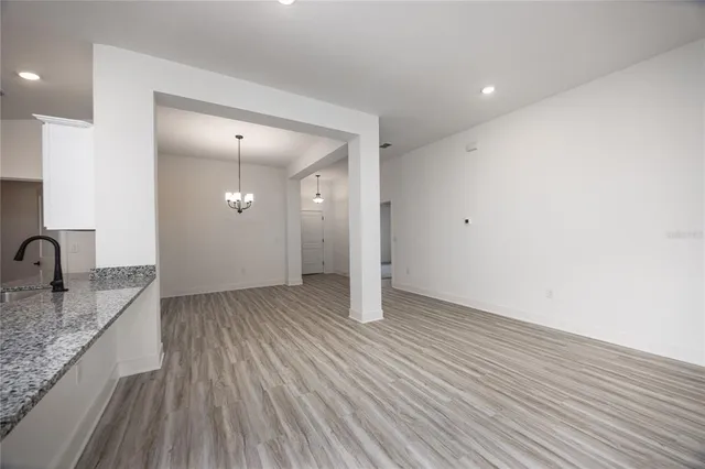 an empty room with wooden floor and a sink