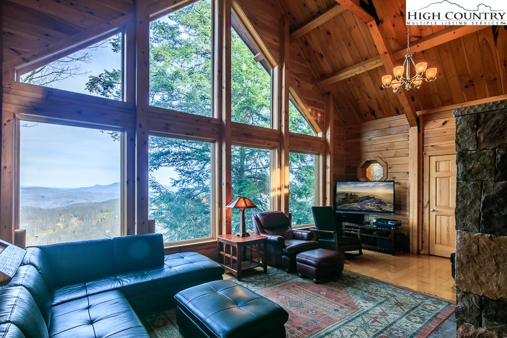 a living room with furniture tv and a floor to ceiling window