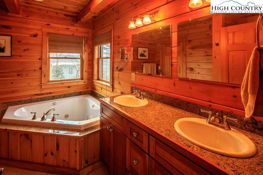 204 Pinnacle Ridge Road Beech Mountain, NC 28604 - Photo 25 of 50 a bathroom with a tub sink and mirror