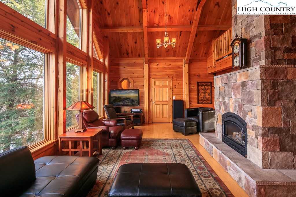 204 Pinnacle Ridge Road Beech Mountain, NC 28604 - Photo 5 of 50 a living room with furniture a fireplace and large windows