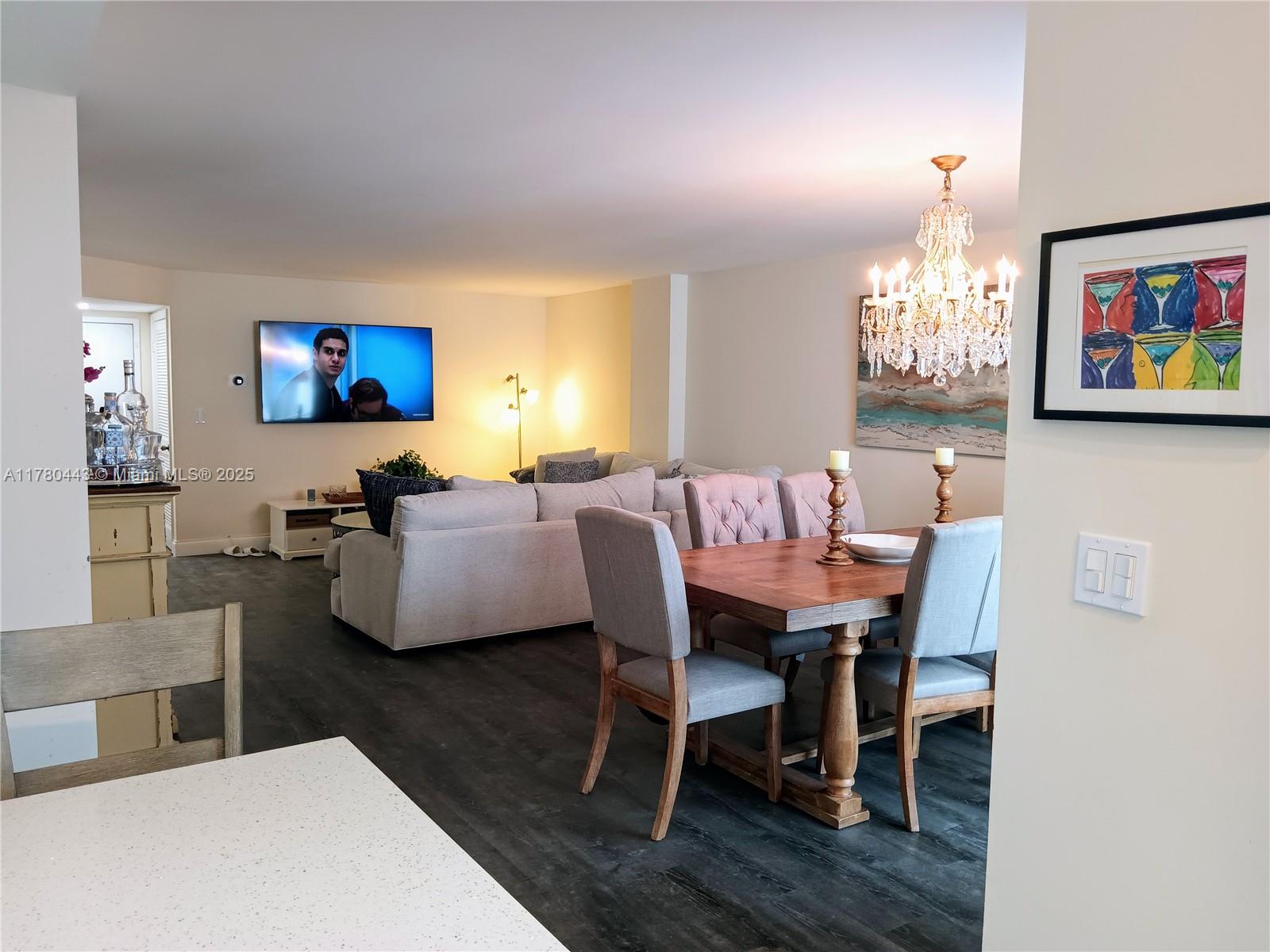 1000 South Ocean Boulevard, Unit 10E Pompano Beach, FL 33062 - Photo 40 of 64 a living room with furniture a chandelier and a flat screen tv