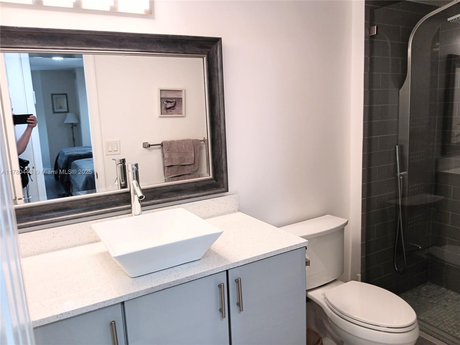 1000 South Ocean Boulevard, Unit 10E Pompano Beach, FL 33062 - Photo 52 of 64 a bathroom with a sink a toilet a mirror and shower