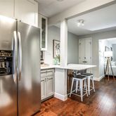 a kitchen with stainless steel appliances granite countertop a refrigerator a stove and a dining table with wooden floor