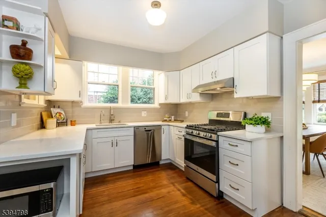 a kitchen with a stove a sink and a window