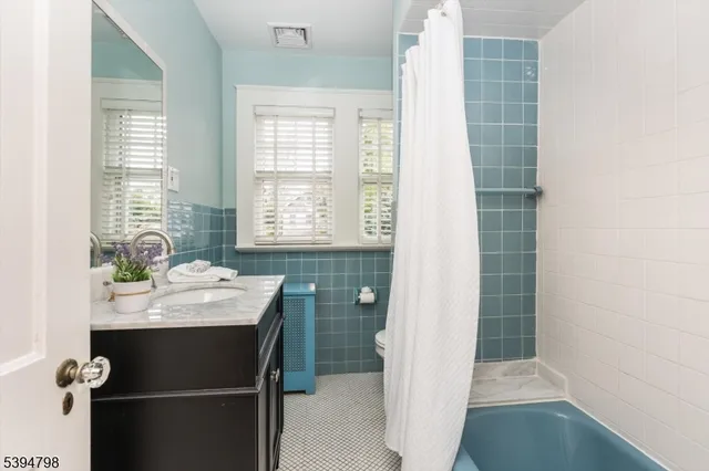 a bathroom with a granite countertop sink a toilet and shower