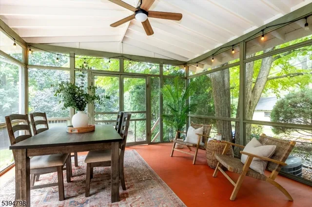 a dining room with furniture large windows and wooden floor