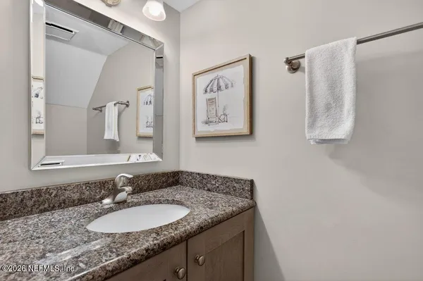 a bathroom with a granite countertop sink and a mirror
