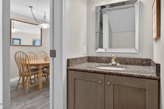 a en suite bathroom with a granite countertop sink and a mirror