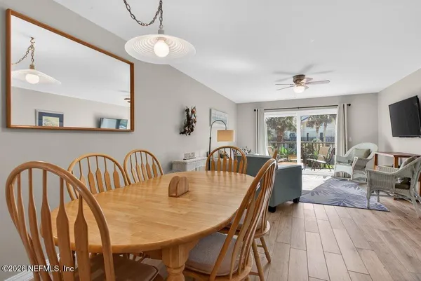 a dining room with furniture a chandelier and wooden floor