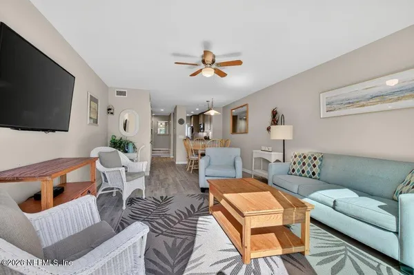 a living room with furniture a flat screen tv and a window