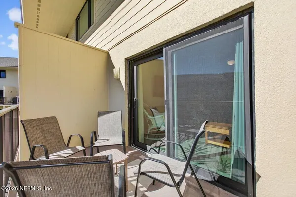 a balcony view with a large window and sitting space