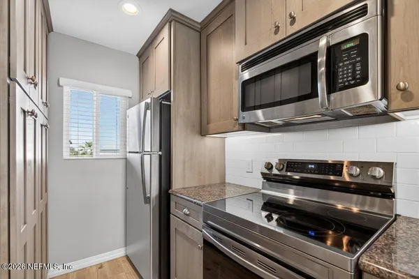 a kitchen with stainless steel appliances a refrigerator and a microwave