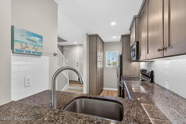 a kitchen with a refrigerator sink and cabinets