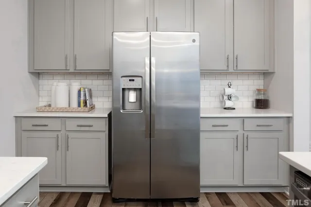 a kitchen with a refrigerator sink and cabinets