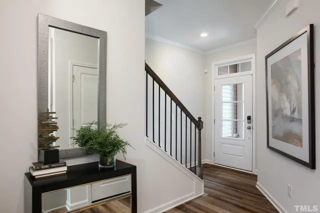 a view of a hallway with wooden floor and a potted plant