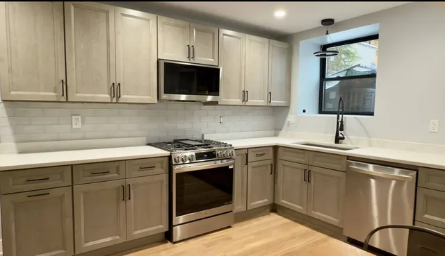 a kitchen with stainless steel appliances granite countertop a sink and a microwave