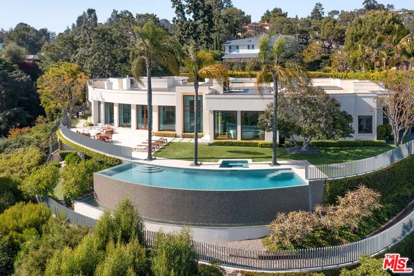 a view of a house with pool and trees