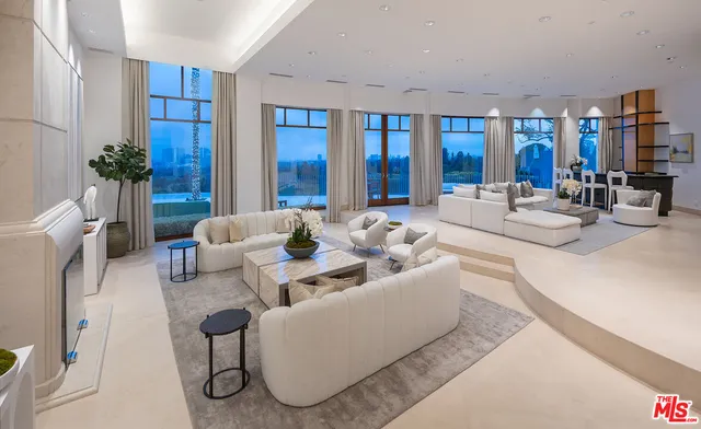 a living room with furniture potted plant and glass door