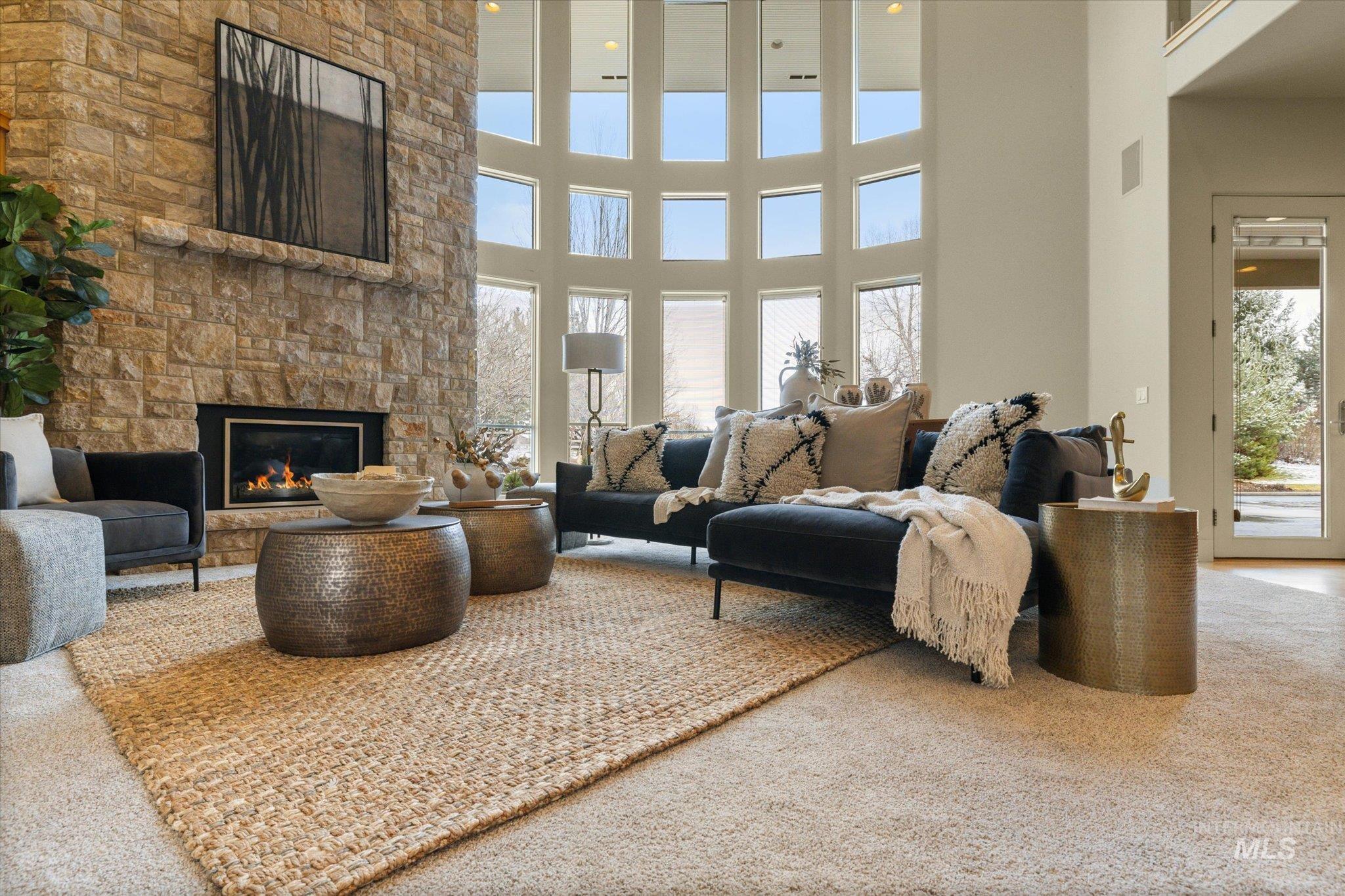 1400 North Razza Way Eagle, ID 83616 - Photo 12 of 50 Living area with carpet floors, a high ceiling, and a fireplace