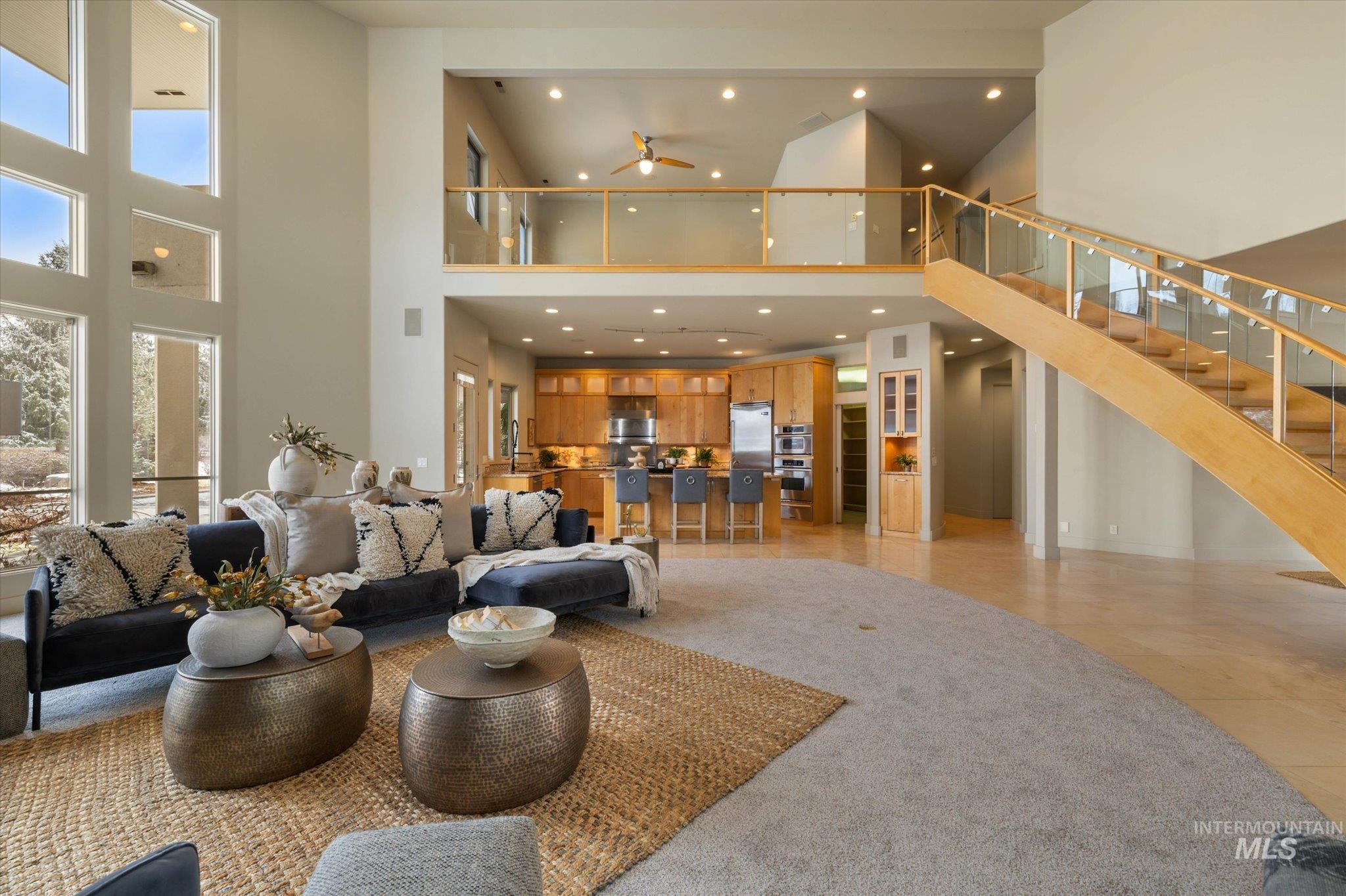 1400 North Razza Way Eagle, ID 83616 - Photo 13 of 50 Living area featuring light tile patterned floors, a high ceiling, recessed lighting, ceiling fan, and light carpet