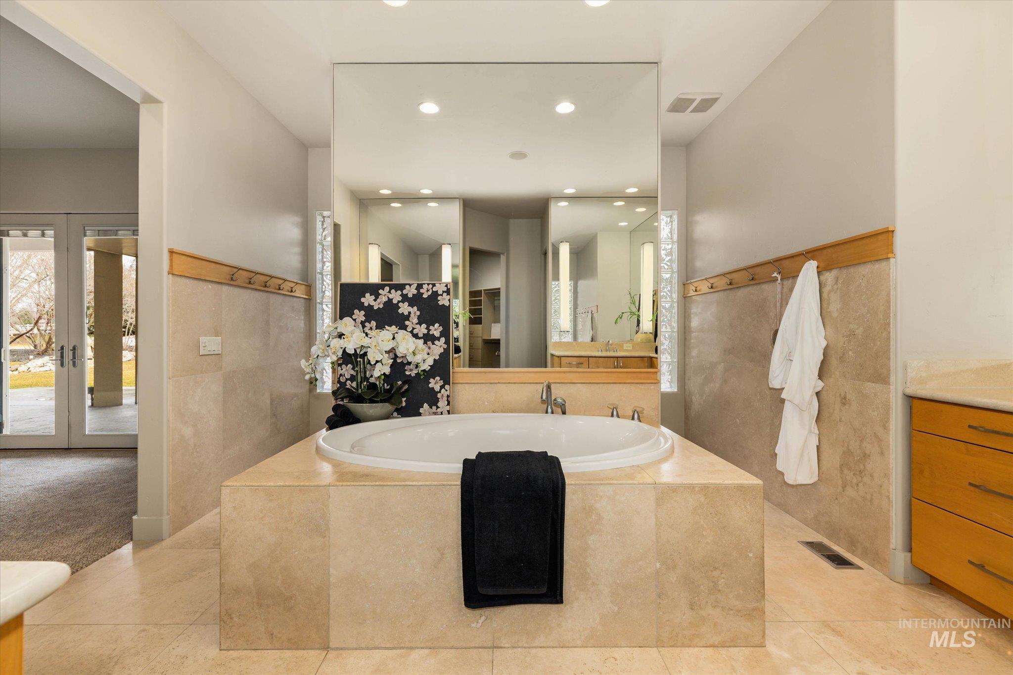 1400 North Razza Way Eagle, ID 83616 - Photo 22 of 50 Full bath featuring vanity, a bath, french doors, tile walls, and recessed lighting